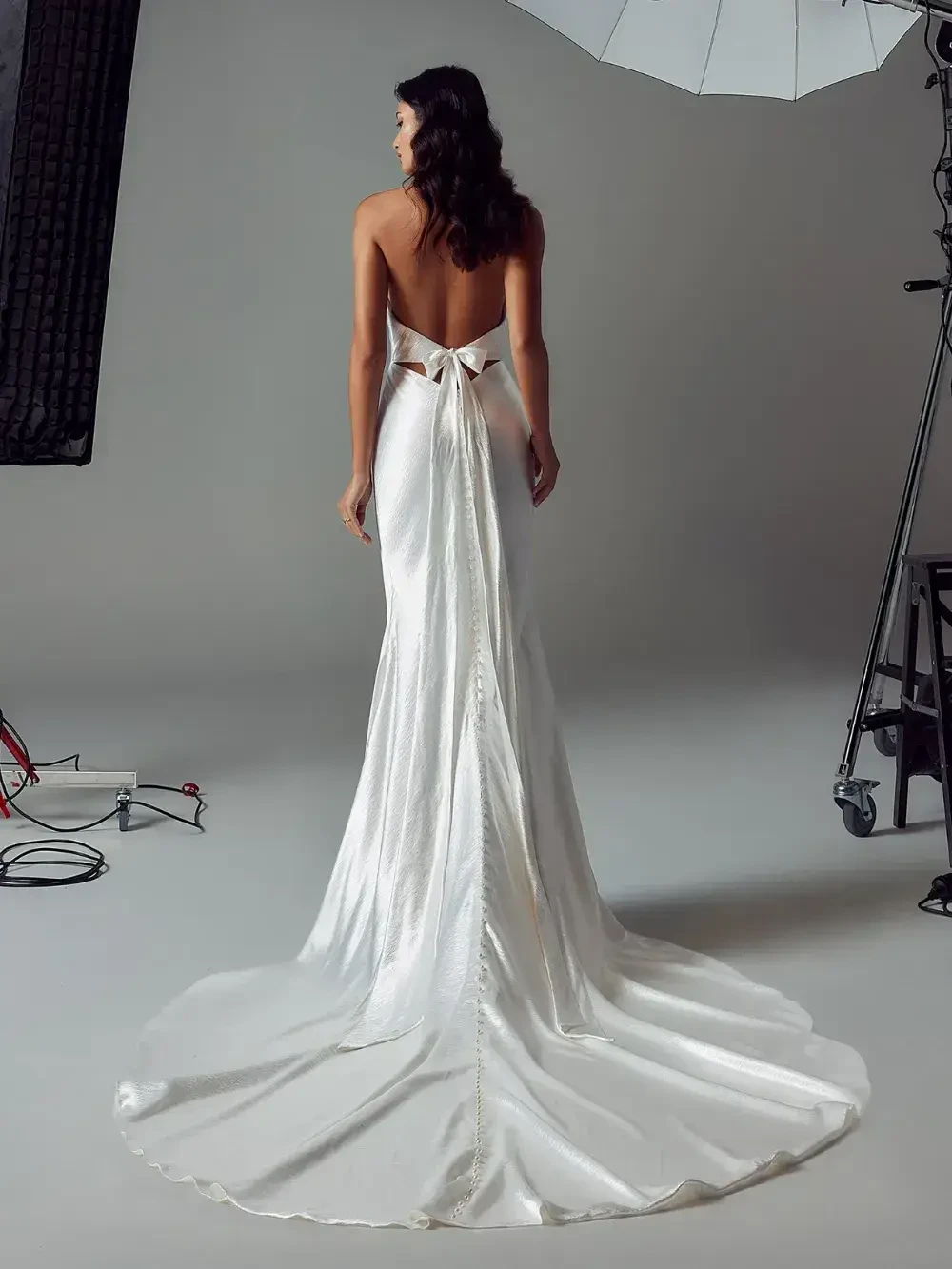 model is wearing a sleeveless bridal gown with a cowl neckline