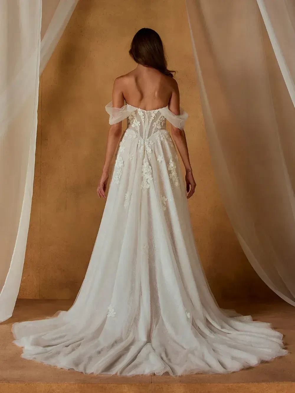 model is wearing an off the shoulder bridal gown