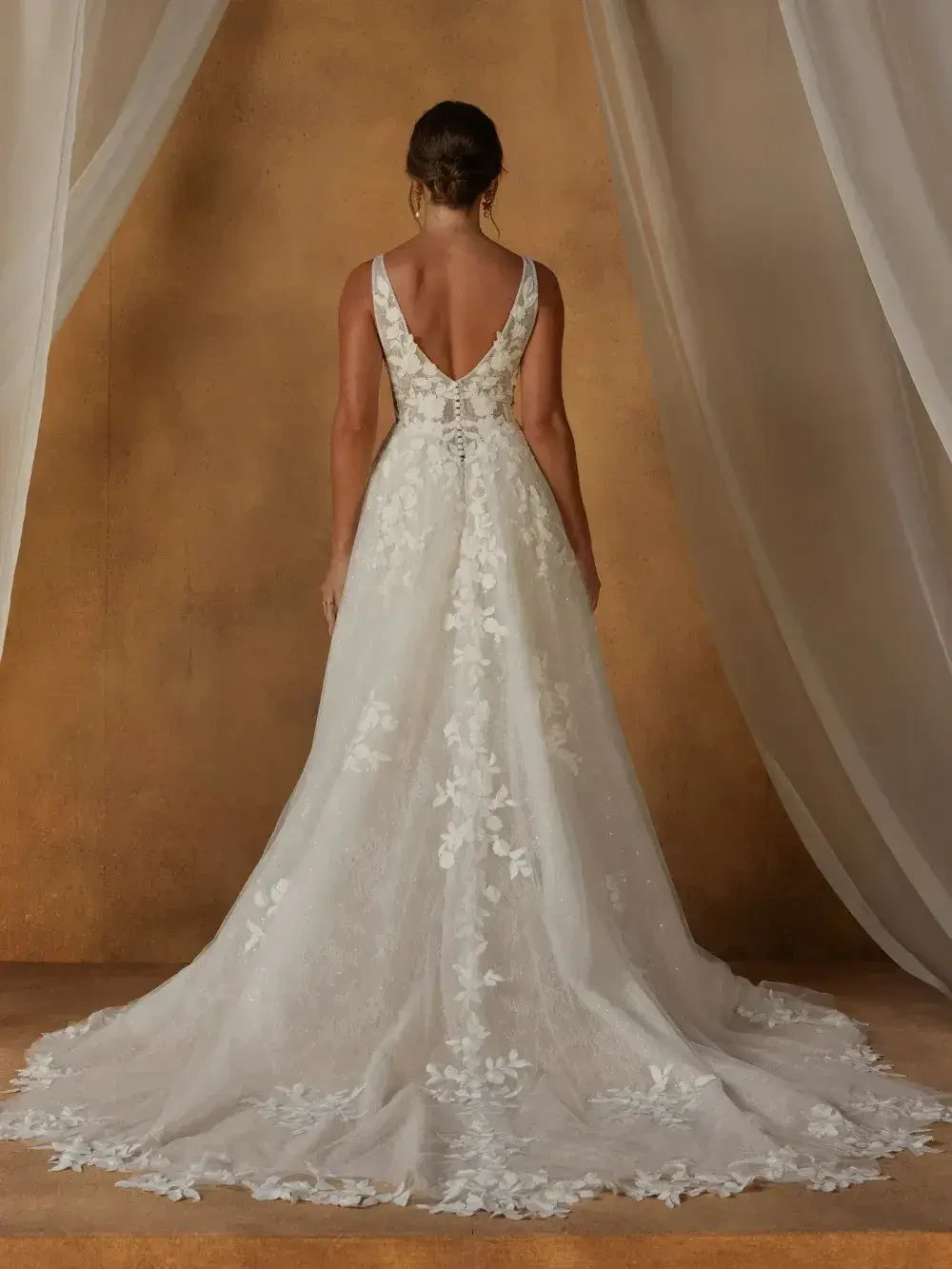 model is wearing an open back sleeveless gown